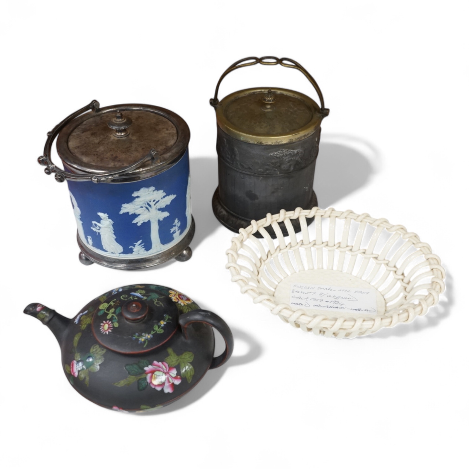 A collection of Wedgwood comprising basalt and jasper biscuit barrels, an enamelled basalt teapot, and a cover and creamware basket, largest 26cm high (4)